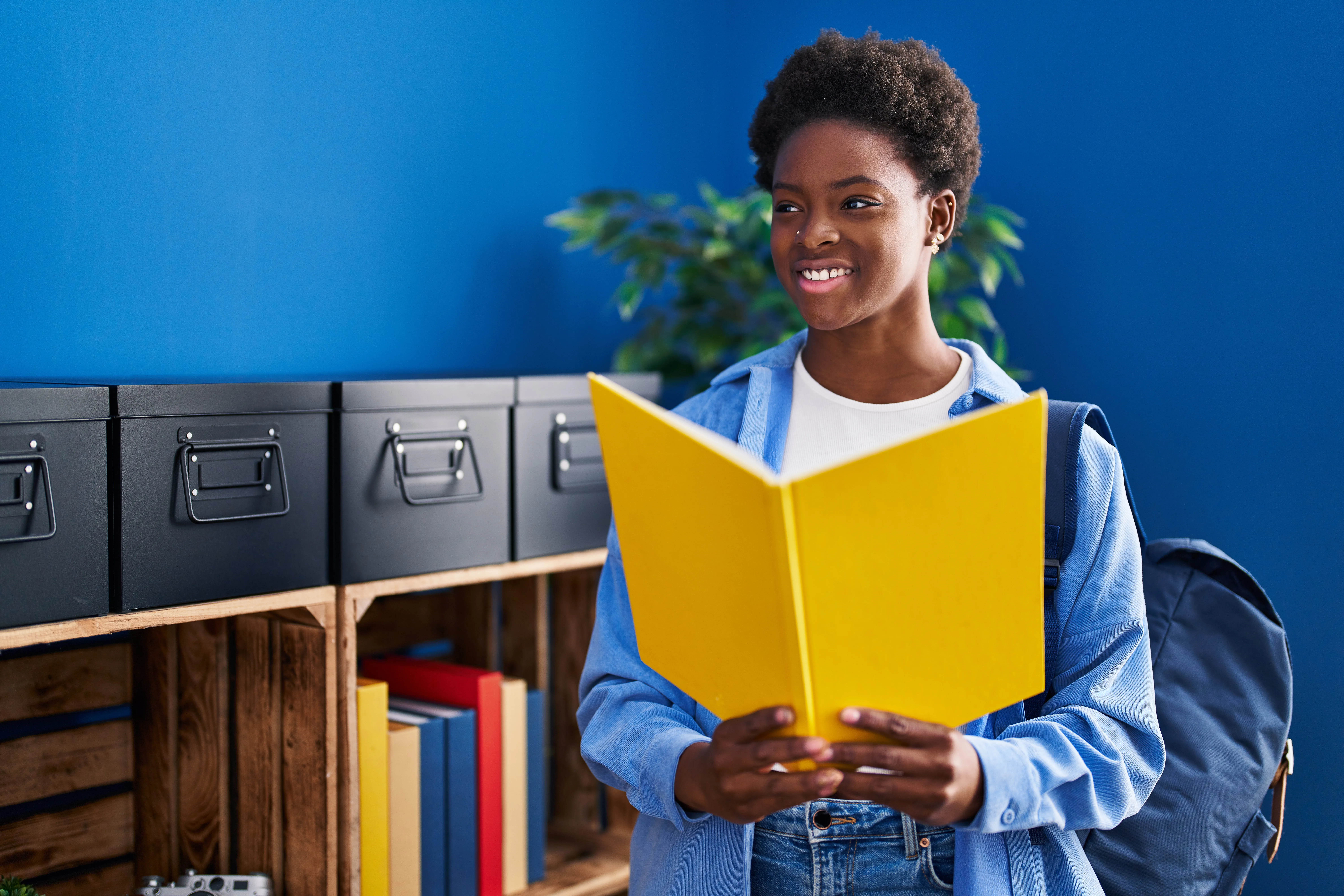 african-american-woman-reading-book-standing-home